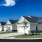 a row of houses with paved driveways and a blue sky in the background