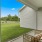a patio with a couch and a table and a chair and a grass field