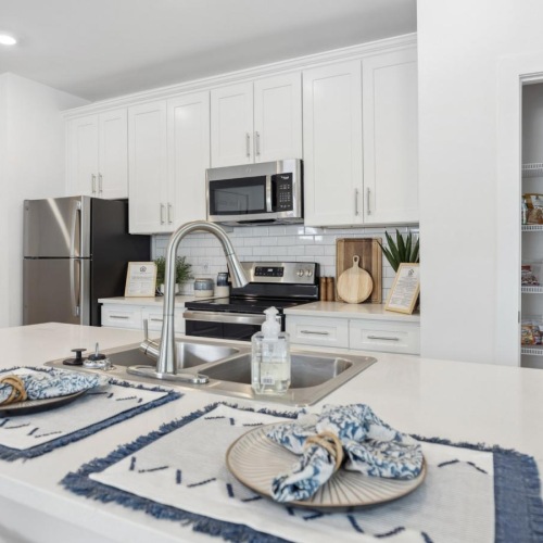 Refined spaces to match your style Model kitchen at River Rock at Blume Road homes for rent in Mooresville, NC, featuring stainless steel appliances.