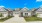 a row of houses with paved driveways and a blue sky in the background